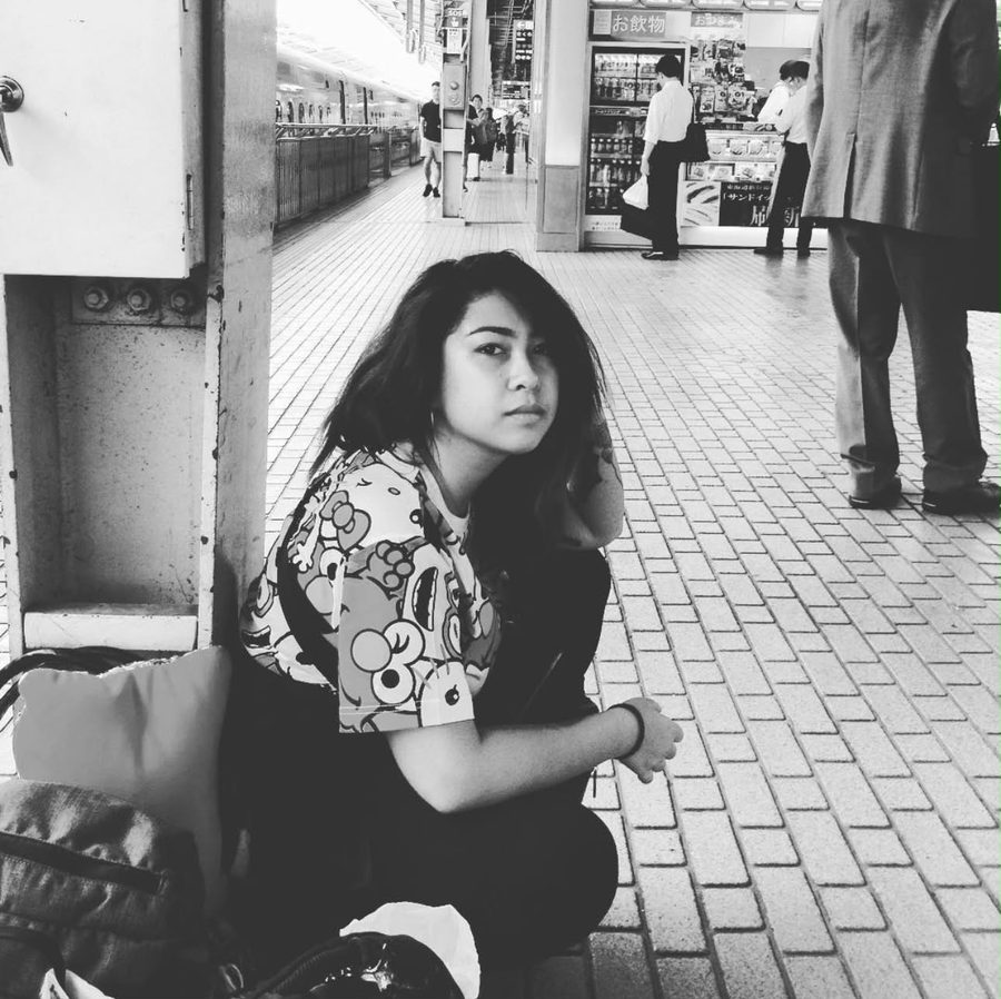 Yume Huang sitting on a train platform in Osaka, Japan, in black and white